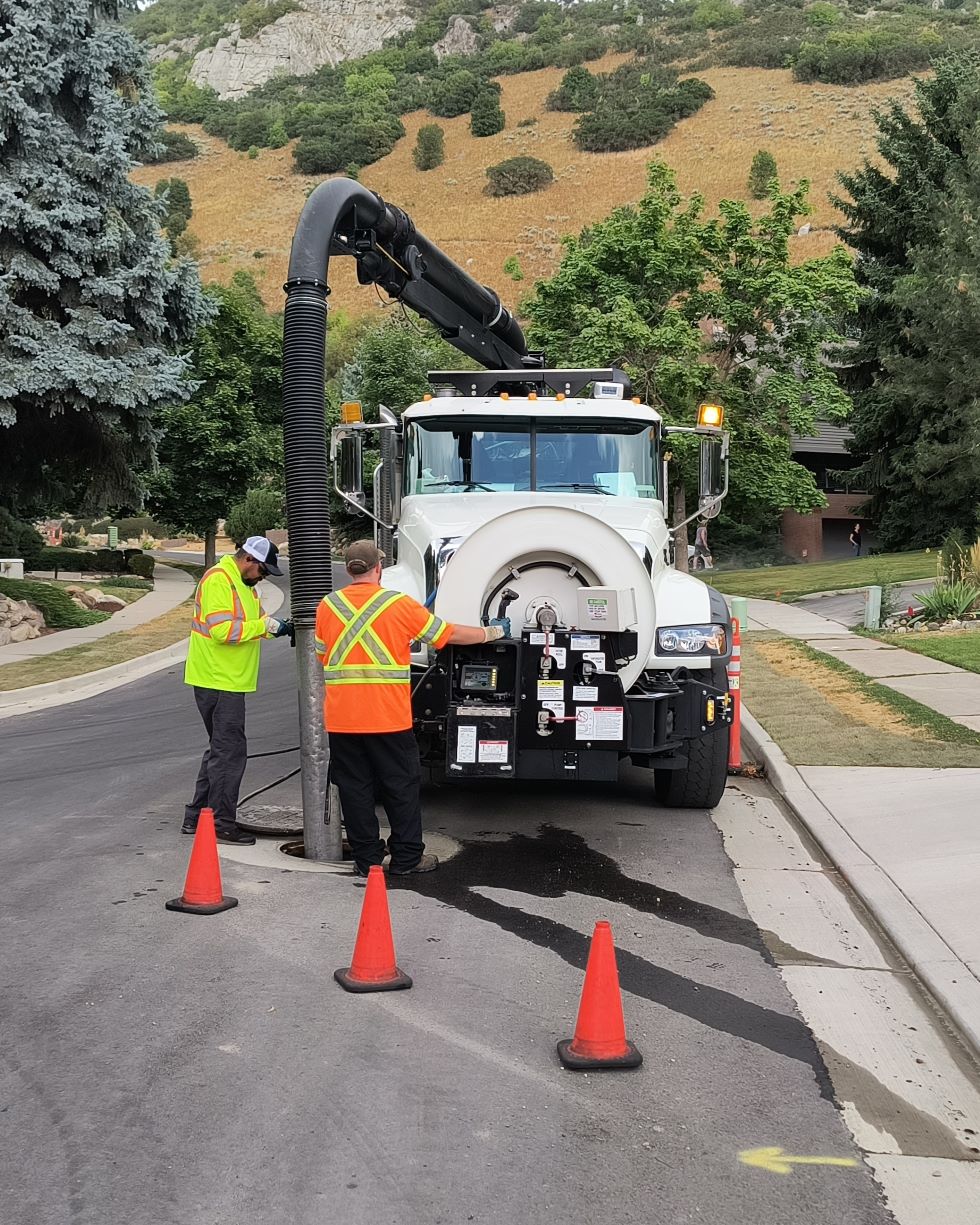 A large sewer cleaing truck is shown on a roadway.